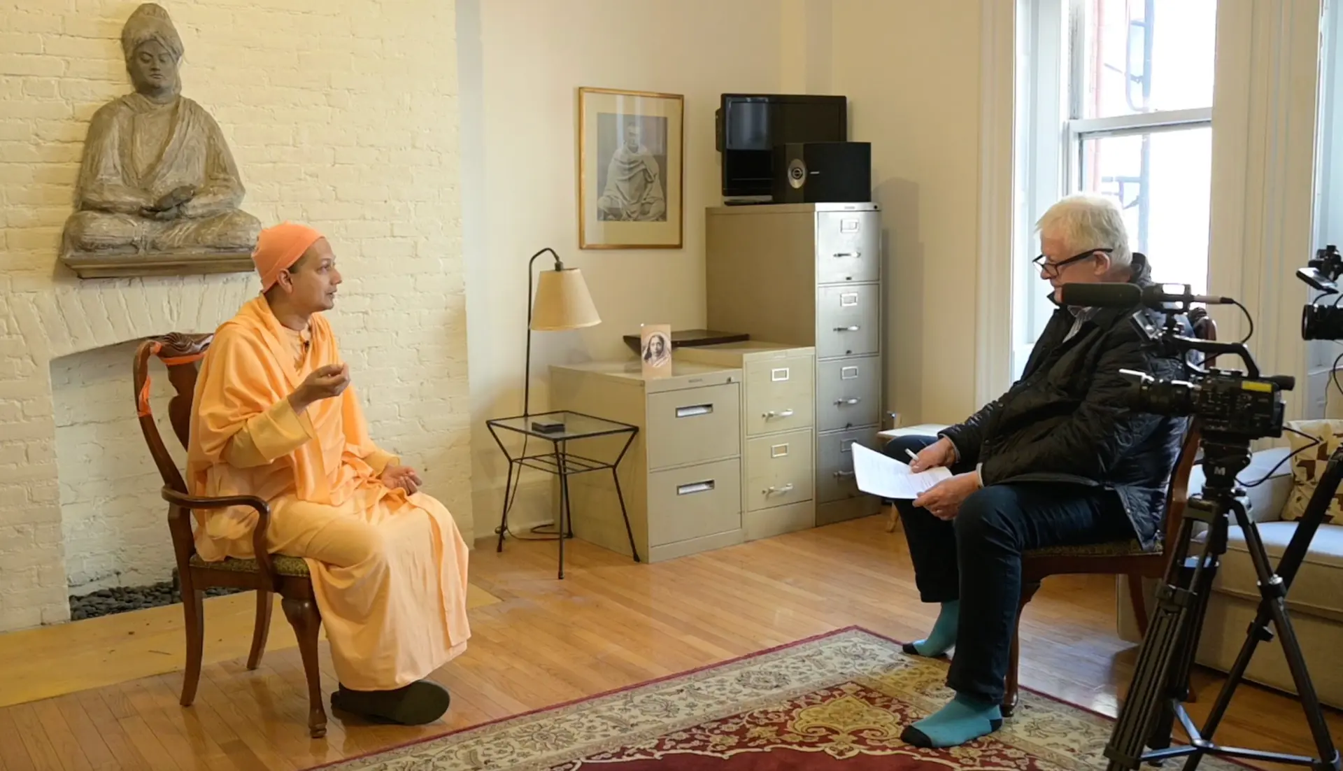 A filmed interview in progress with a monk, part of Infinite Potential's dialogue series